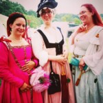 Courtesans Chiaretta di Fiore and Bianca Anguissola with friend Gritta of Strangewayes posing as they arrive at the Pennsic Knowne World Courtesans Social on August 10, 2017 Three people wearing Renaissance clothing posing together