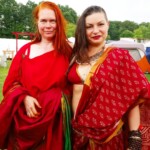 Two courtesans posing as they arrive at the Pennsic Knowne World Courtesans Social on August 10, 2017 Two people posing together, one wearing ancient Roman clothing, the other wearing Indian clothing