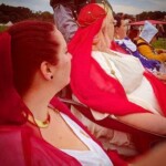 Courtesans, Patrons, and Tullians observing the Pennsic Unbelted Champions Battle on August 6, 2017 Several people dressed in ancient Roman, medieval, and Renaissance clothing sitting and standing in a group facing away from the camera