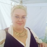 Courtesan Fortune St Keyne after teaching her History of Kissing and Italian Drawers classes at Pennsic on August 5, 2017 Closeup of a woman in ancient Roman clothing inside a popup tent with walls