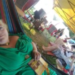 Courtesans Bianca Anguissola and Fortune St Keyne with friend Gritta of Strangewayes during "romance novel time" at Pennsic on August 8, 2017 A woman in ancient Roman clothing laying in a hammock with a open book on her stomach while behind her two other people in ancient and Renaissance clothing sit in camp chairs reading books