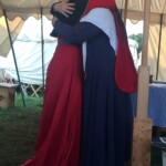 Courtesan Esa inghean Donnchaidh with her Laurel Beatriz Aluares de la Oya at their apprentice ceremony at Pennsic on August 3, 2017 Two people in medieval clothing embracing each other inside a medieval style tent