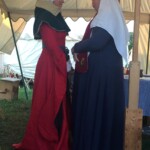 Courtesan Esa inghean Donnchaidh with her Laurel Beatriz Aluares de la Oya at their apprentice ceremony at Pennsic on August 3, 2017 Two people in medieval clothing facing each other inside a medieval style tent