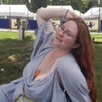 Courtesan Bianca Anguissola at Pennsic on August 4, 2018 A woman in ancient Roman clothing posing her one hand in her hair outdoors