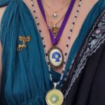 Courtesan Ginevra Fiammetta di Silvestri's medallions for the Order of the Pearl at Ruby Joust in Atlantia on May 27th, 2023 Closeup selfie of a woman in ancient Roman clothing wearing a red veil, a gold stag pin, and several necklaces, three of which have scallop shells and pearls on them